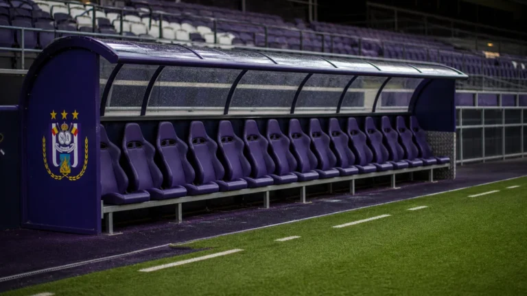 Lege dug-out van Anderlecht na de wedstrijd met een clubembleem op het zijpaneel.