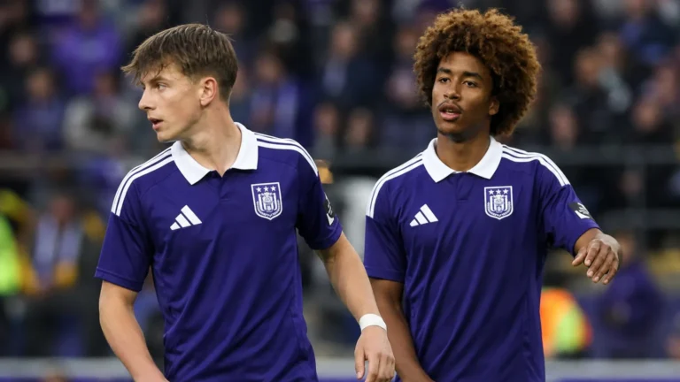 Twee voetballers in paarse shirts tijdens een neutraal wedstrijdmoment.