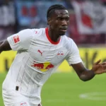 Ezechiel Banzuzi in het witte tenue van RB Leipzig tijdens een spelmoment.