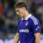 Een Anderlecht-speler reageert teleurgesteld op het veld in een paars wedstrijdshirt.