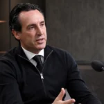 Unai Emery spreekt in een rustige clubmedia-interviewruimte met een microfoon voor zich.