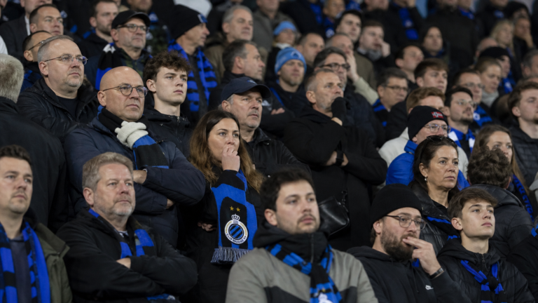 Teleurgestelde Club Brugge-supporters met blauw-zwarte sjaals in de tribunes.