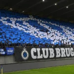 Collectieve Club Brugge-supporters op een overdekte tribune met een blauw-witte kaartenmozaïek.
