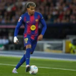 Een voetballer in een blauw-rood tenue tijdens een wedstrijdmoment.