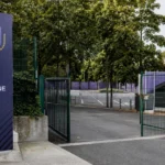 Lege toegang naar de Fanzone van RSC Anderlecht met een clubembleem op een wegwijzer.