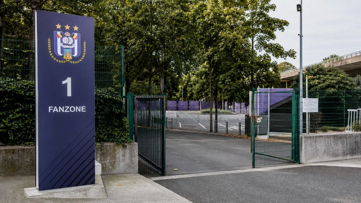 Lege toegang naar de Fanzone van RSC Anderlecht met een clubembleem op een wegwijzer.