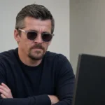 Joey Barton tijdens een videogesprek in een sobere juridische setting.