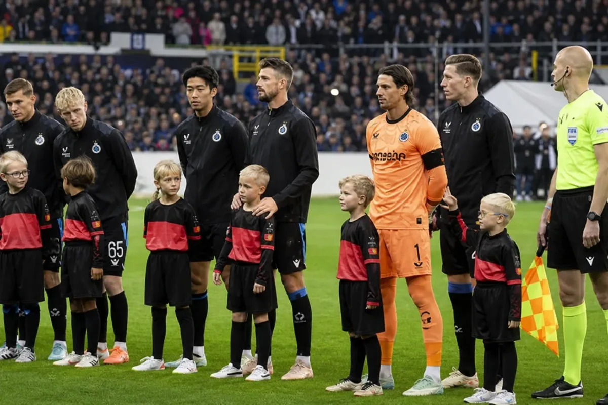 Club Brugge-spelers staan met pupilspelers opgesteld op het veld voor een Champions League-wedstrijd.