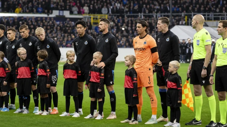 Club Brugge-spelers staan met pupilspelers opgesteld op het veld voor een Champions League-wedstrijd.