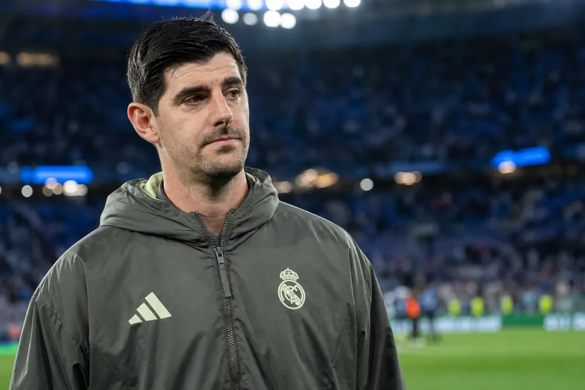 Thibaut Courtois in een donkere Real Madrid-jas aan de rand van het veld na een wedstrijd.