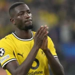 Serhou Guirassy applaudisseert op het veld in zijn gele Borussia Dortmund-shirt.