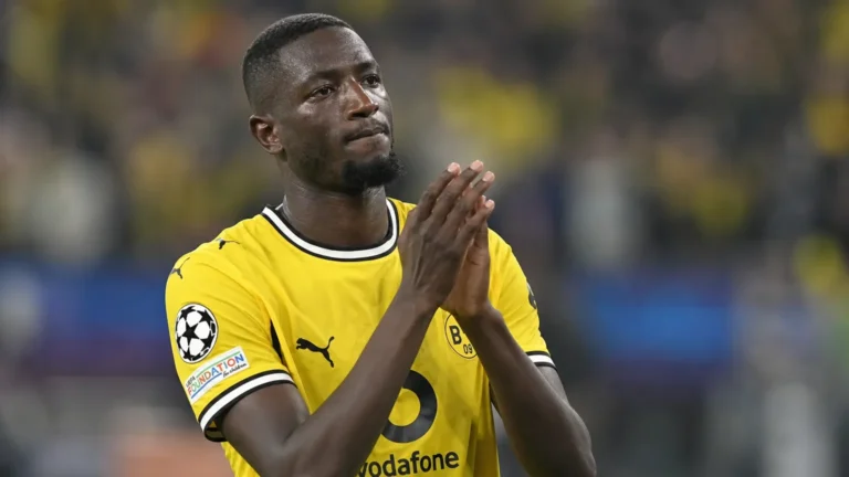 Serhou Guirassy applaudisseert op het veld in zijn gele Borussia Dortmund-shirt.