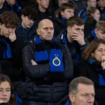 Teleurgestelde Club Brugge-supporters op de tribune met blauw-zwarte sjaals.