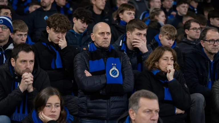Teleurgestelde Club Brugge-supporters op de tribune met blauw-zwarte sjaals.