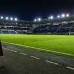 Leeg veld in het Jan Breydelstadion met een Club Brugge-embleem op de dug-out.