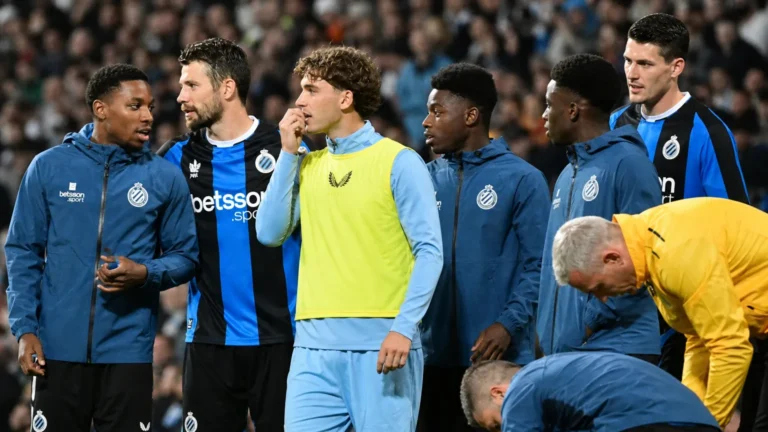 Een groep spelers en stafleden van Club Brugge langs de zijlijn van een stadion.