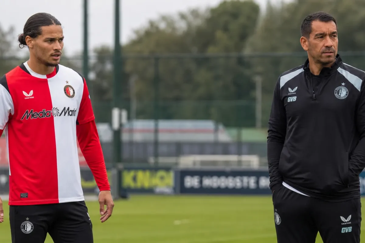 Een Feyenoord-speler en een staflid op het trainingsveld.