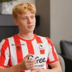 Cedric Hatenboer spreekt tijdens een voetbalinterview in een rood-wit gestreept shirt.