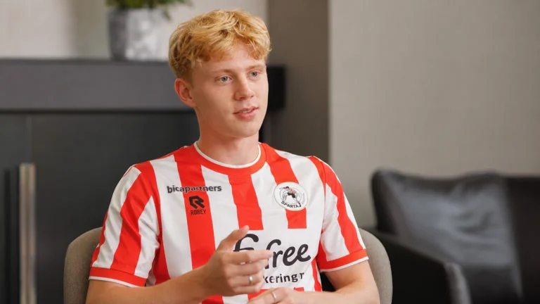 Cedric Hatenboer spreekt tijdens een voetbalinterview in een rood-wit gestreept shirt.
