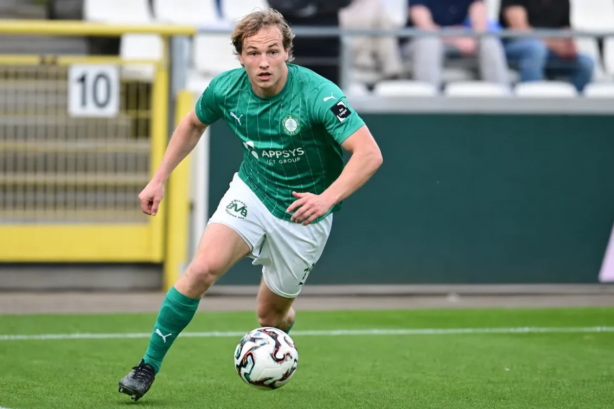 Een Lommel SK-speler in groen wedstrijdtenue tijdens een wedstrijdactie.