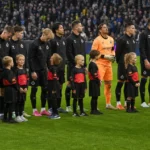 Een groep spelers van Club Brugge staat met mascottes en een scheidsrechter opgesteld op het veld.