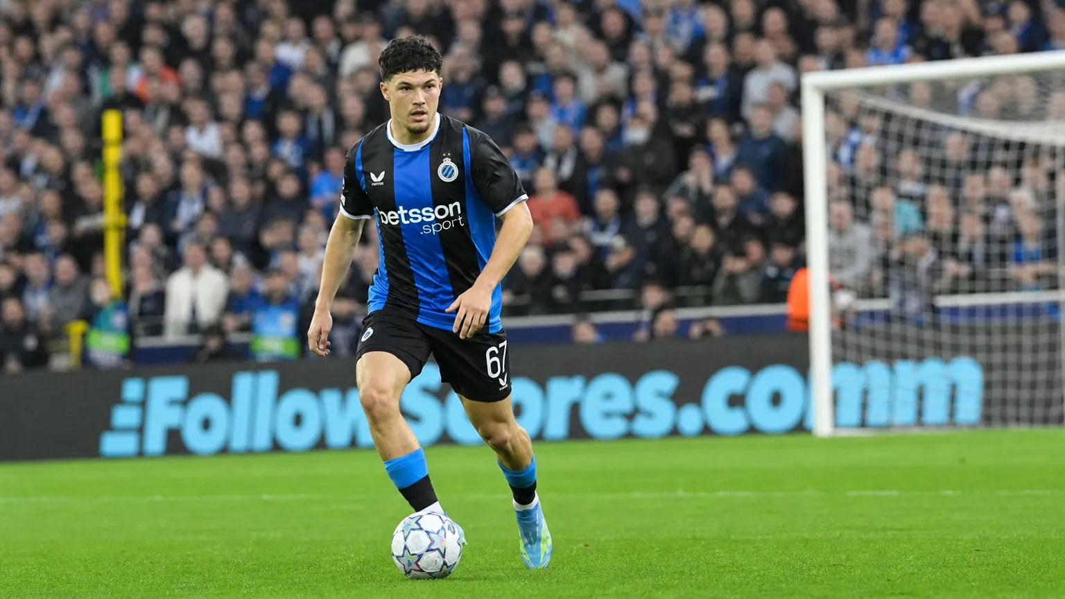 Een speler van Club Brugge dribbelt met de bal tijdens een wedstrijd.