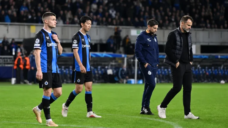 Spelers en stafleden van Club Brugge wandelen na het eindsignaal langs de zijlijn.