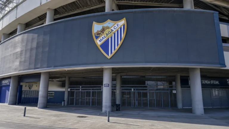 Lege ingang van het stadion van Málaga met een clubembleem aan de gevel.