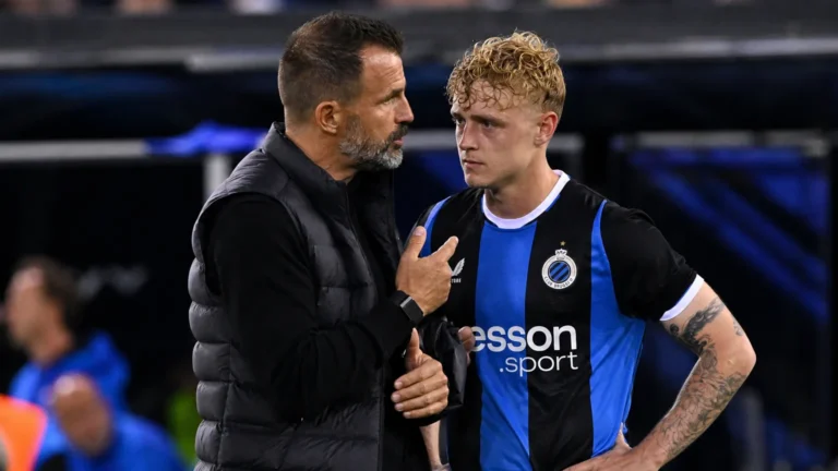 Een Club Brugge-speler en een staflid in gesprek langs de zijlijn na een wedstrijd.