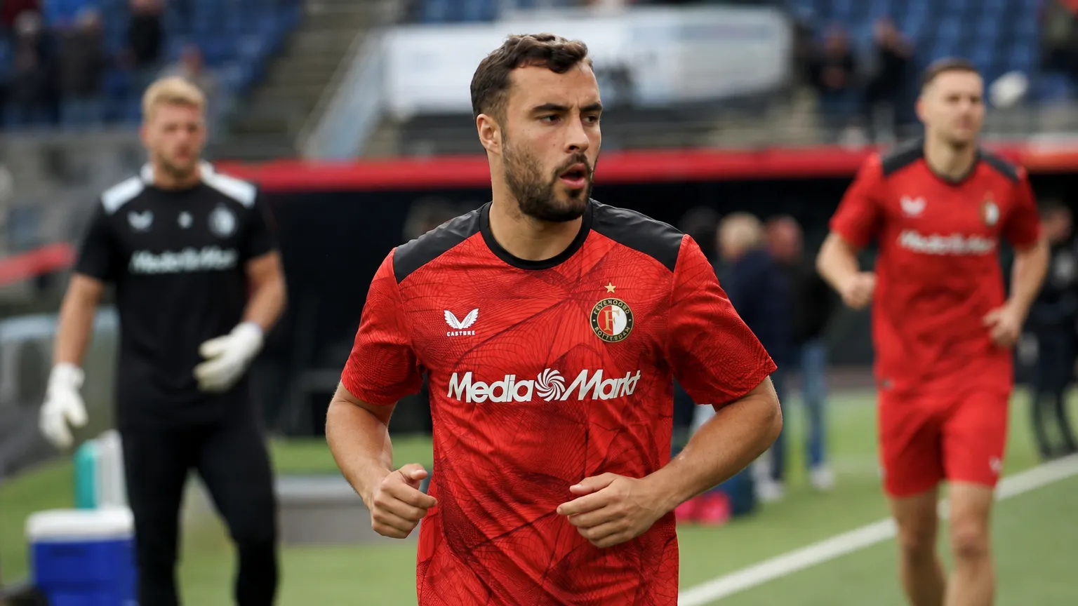 Charles Vanhoutte warmt op in Feyenoord-tenue in een stadion.