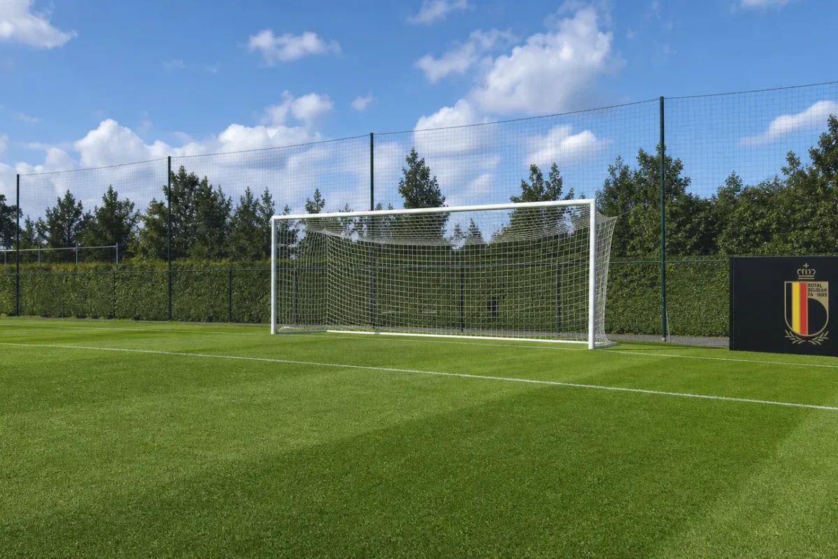 Een leeg doel op het trainingsveld met een vast bord van België naast het veld.