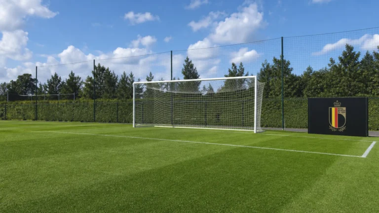 Een leeg doel op het trainingsveld met een vast bord van België naast het veld.