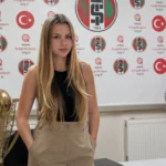 Zeynep Mestan in burgerkleding voor een zichtbare Turgutluspor-clubachtergrond.