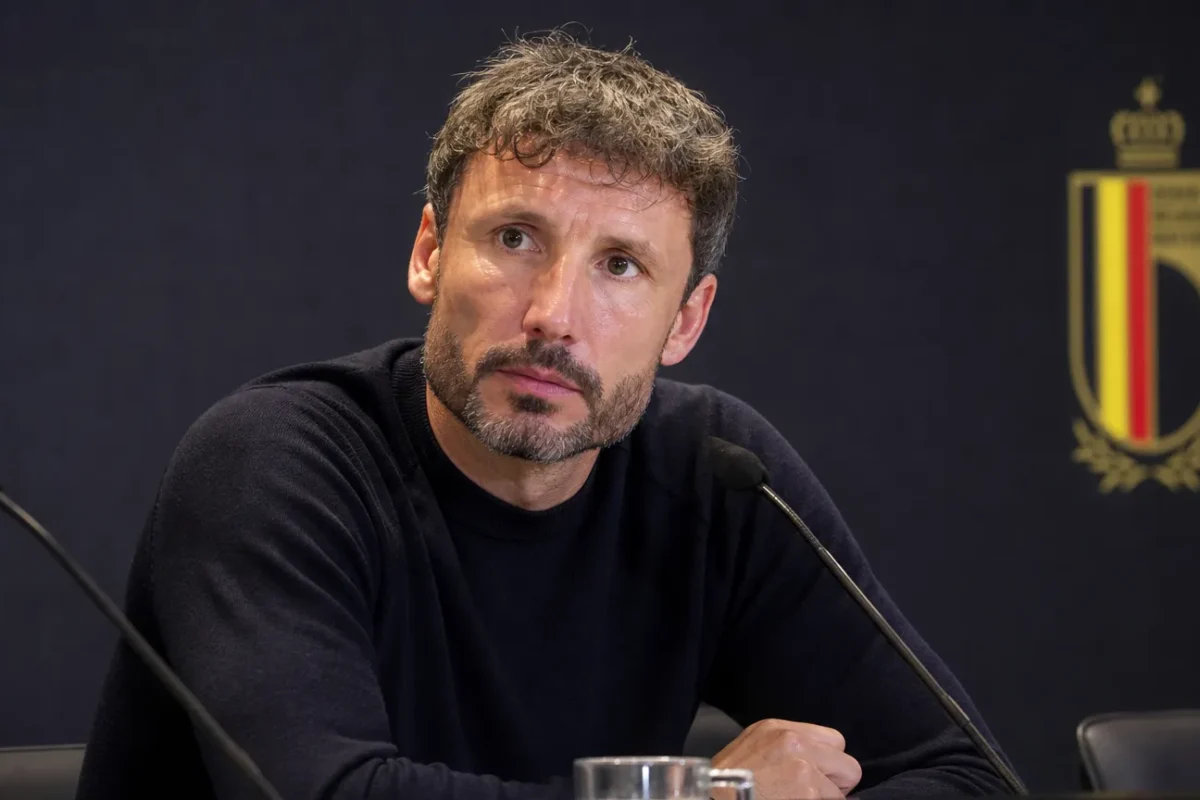 Mark van Bommel zit aandachtig aan een persdesk bij de Rode Duivels.