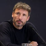 Mark van Bommel zit aandachtig aan een persdesk bij de Rode Duivels.