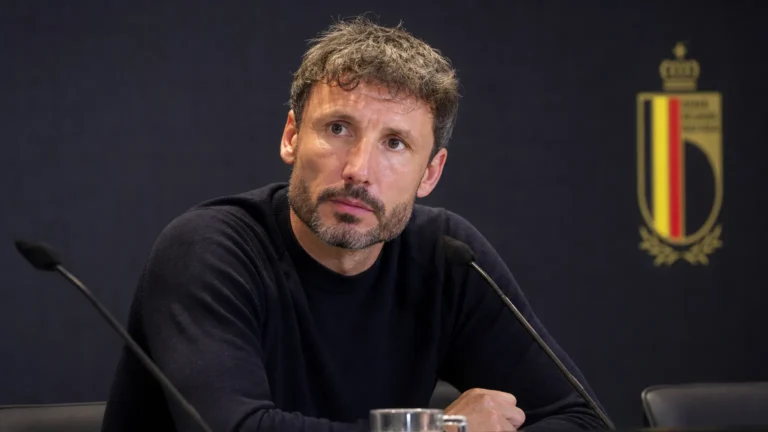 Mark van Bommel zit aandachtig aan een persdesk bij de Rode Duivels.