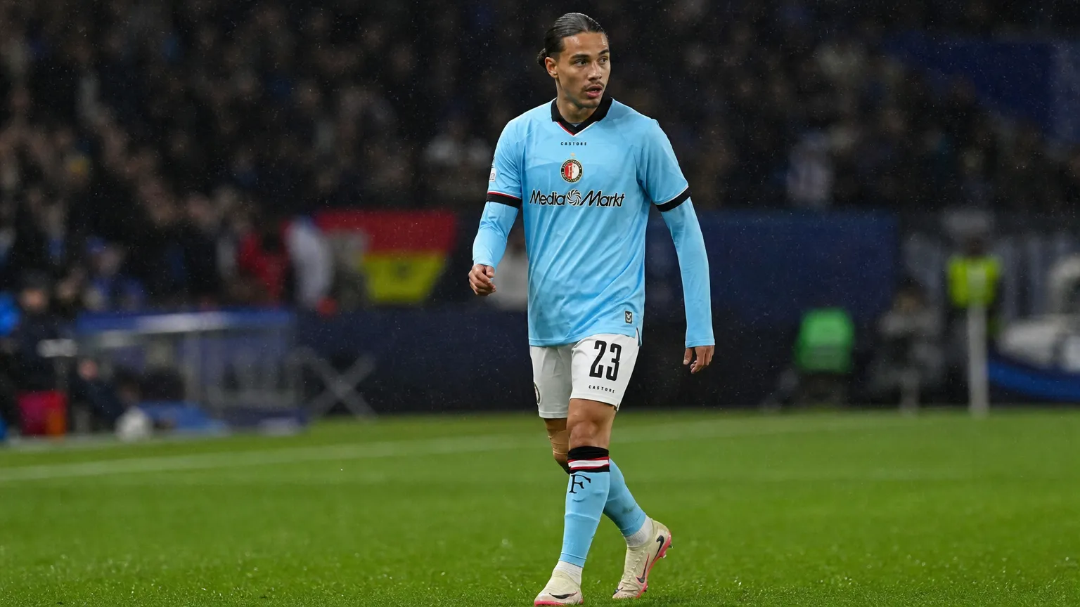 Een Feyenoord-speler in lichtblauw tenue tijdens een wedstrijdmoment op het veld.