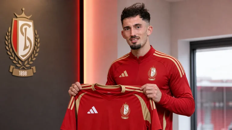 Andi Zeqiri poseert met een Standard-shirt tijdens zijn voorstelling in Luik.