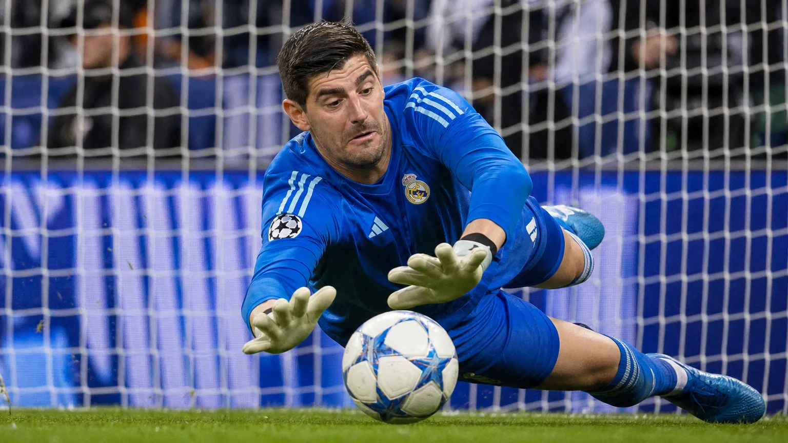Thibaut Courtois duikt in het doelgebied van Real Madrid naar een redding.