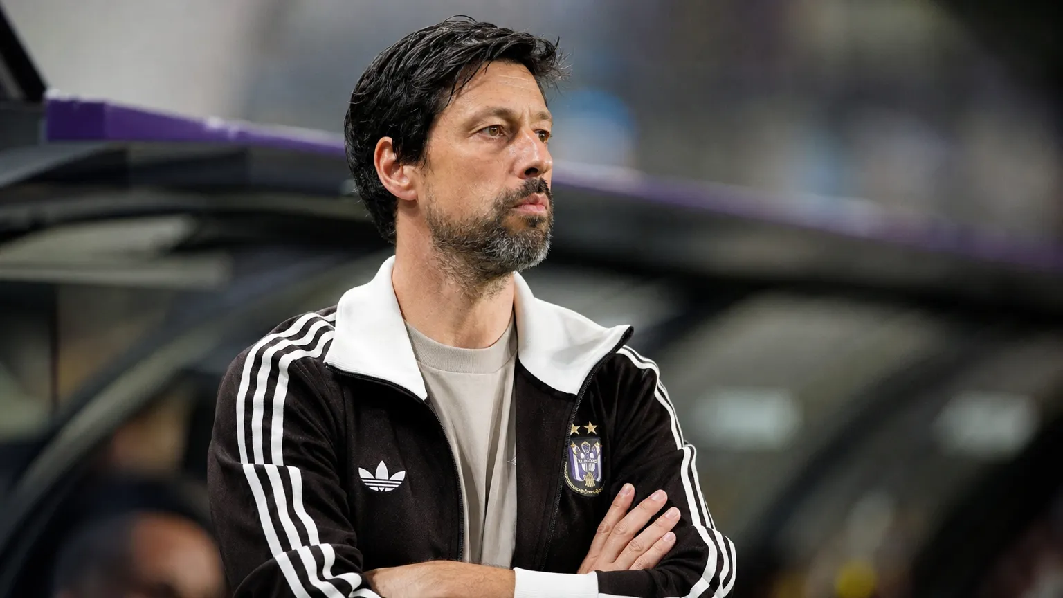 Een Anderlecht-coach volgt aandachtig het spel vanuit de technische zone.