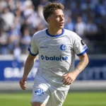 Tibe De Vlieger in actie in het lichtgrijze KAA Gent-shirt met blauwe randen.