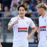 Een groep spelers van KVC Westerlo verzamelt zich tijdens een wedstrijd.