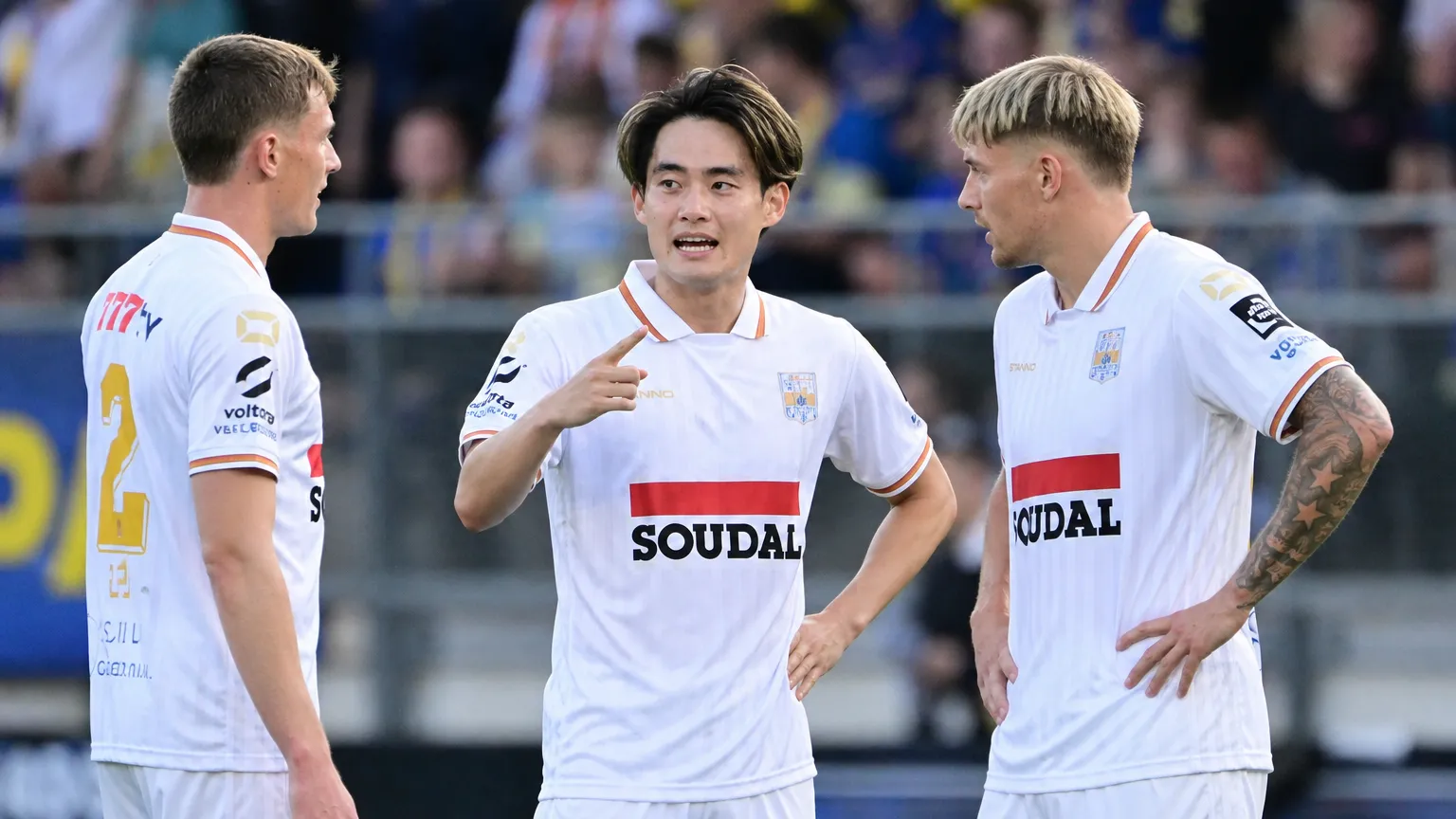 Een groep spelers van KVC Westerlo verzamelt zich tijdens een wedstrijd.