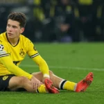 Kos Karetsas van Borussia Dortmund zit op het veld tijdens een medische onderbreking.