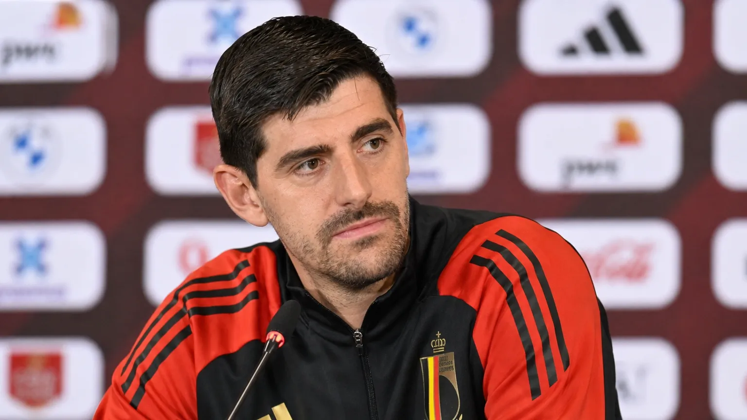 Thibaut Courtois luistert tijdens een persmoment van de Belgische nationale ploeg.