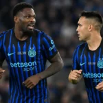 Twee spelers van Inter in blauw-zwarte wedstrijdtenues op het veld.