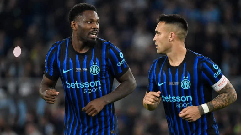 Twee spelers van Inter in blauw-zwarte wedstrijdtenues op het veld.