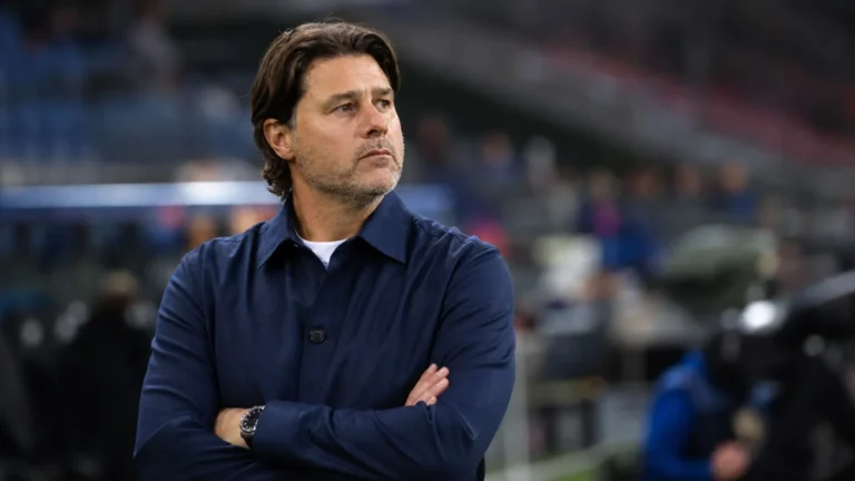 Mauricio Pochettino kijkt aandachtig omhoog in een voetbalstadion.