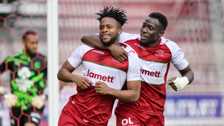 Twee spelers van Zulte Waregem vieren een doelpunt nabij het doel.