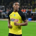 Anthony Martial in een geel-zwart voetbalshirt aan de rand van het veld.